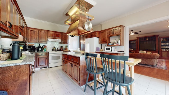 kitchen with ornamental molding, backsplash, a center island, white appliances, and light tile patterned floors