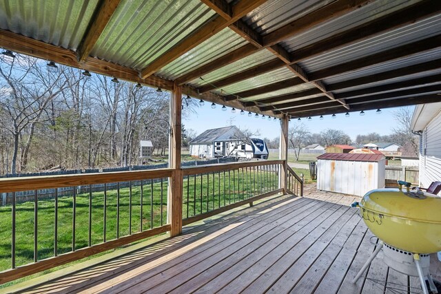 deck featuring a yard, a storage unit, and an outdoor structure
