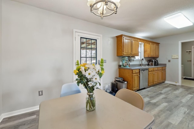 dining area with light wood-type flooring, baseboards, and an inviting chandelier