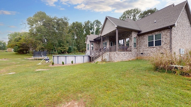1945 Mann Rd, Lebanon, TN 37087 - view of side of home with a trampoline, a lawn, an outdoor pool, a shingled roof, and brick siding