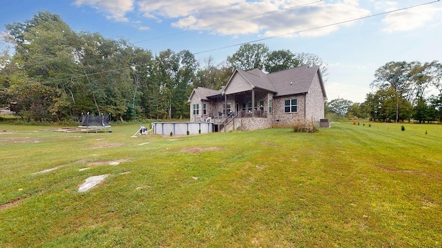 1945 Mann Rd, Lebanon, TN 37087 - back of house with a trampoline, an outdoor pool, a lawn, and brick siding