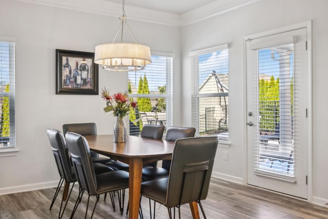 dining room with ornamental molding, baseboards, and wood finished floors