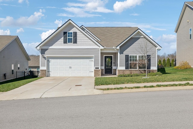 craftsman-style house with brick siding, concrete driveway, a front lawn, and fence