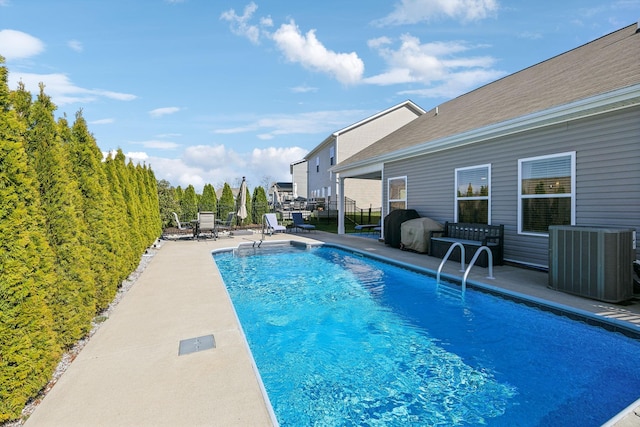 view of swimming pool featuring a patio, central air condition unit, fence, and a fenced in pool