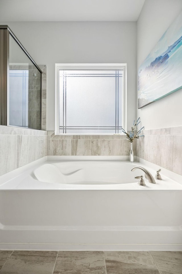 bathroom featuring a garden tub and plenty of natural light