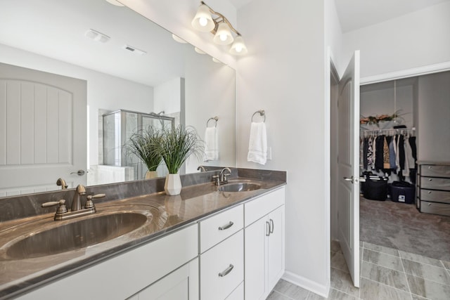 full bath featuring double vanity, visible vents, a shower stall, and a sink