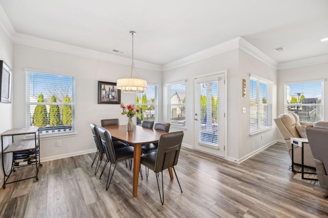 dining space with a notable chandelier, visible vents, baseboards, and wood finished floors