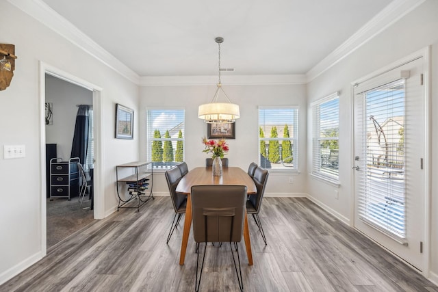 dining space featuring wood finished floors, a notable chandelier, and a healthy amount of sunlight