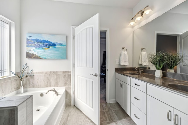 bathroom with double vanity, a bath, and a sink