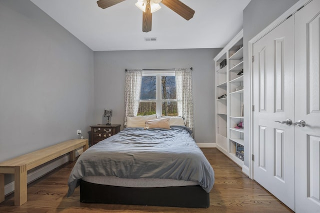bedroom featuring visible vents, baseboards, wood finished floors, and a ceiling fan