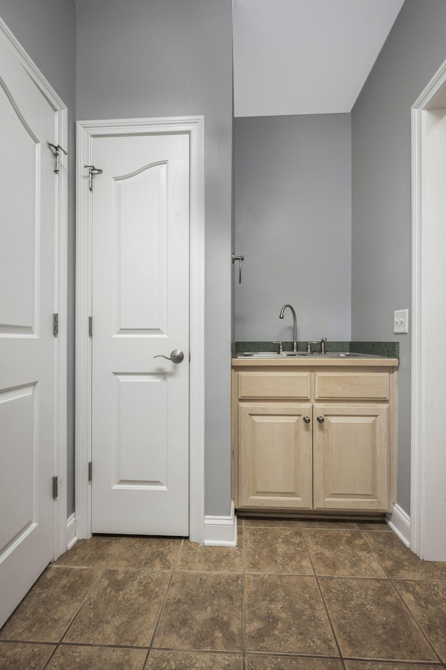 interior space with baseboards and a sink