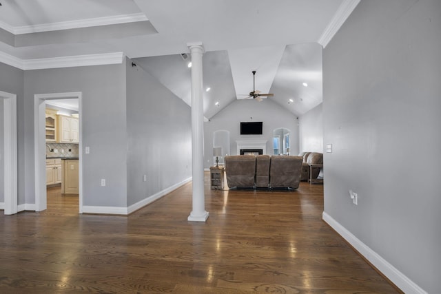 living room with a ceiling fan, baseboards, ornate columns, ornamental molding, and dark wood-type flooring