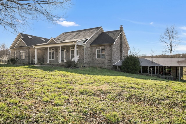 view of front of property featuring roof with shingles, a porch, a chimney, a front lawn, and brick siding