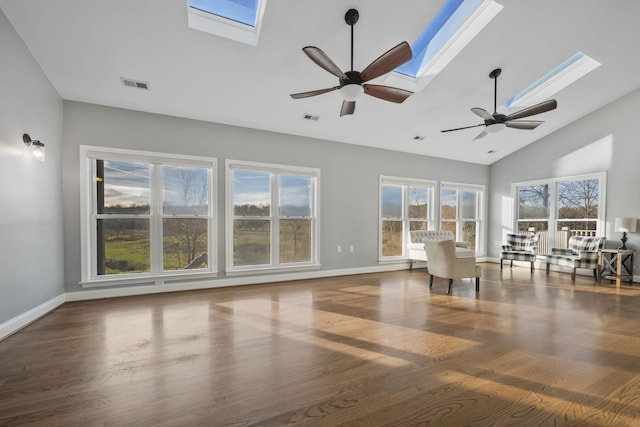 unfurnished living room with ceiling fan, visible vents, wood finished floors, and a skylight