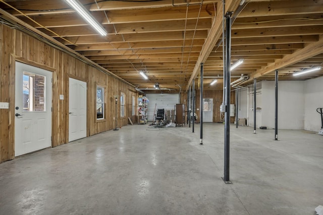 below grade area with wooden walls and a garage