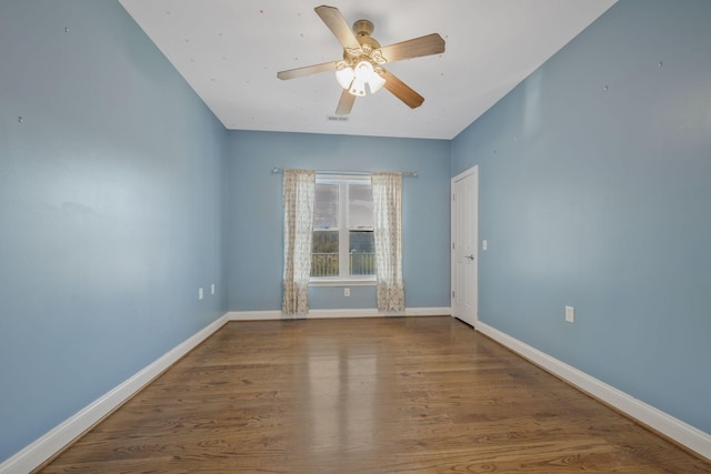 empty room with visible vents, ceiling fan, baseboards, and wood finished floors