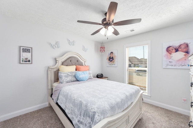 bedroom featuring light carpet, visible vents, and a textured ceiling