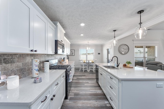 kitchen with crown molding, decorative backsplash, appliances with stainless steel finishes, dark wood-style floors, and a sink