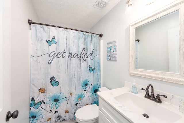 bathroom with visible vents, toilet, vanity, a shower with shower curtain, and a textured ceiling