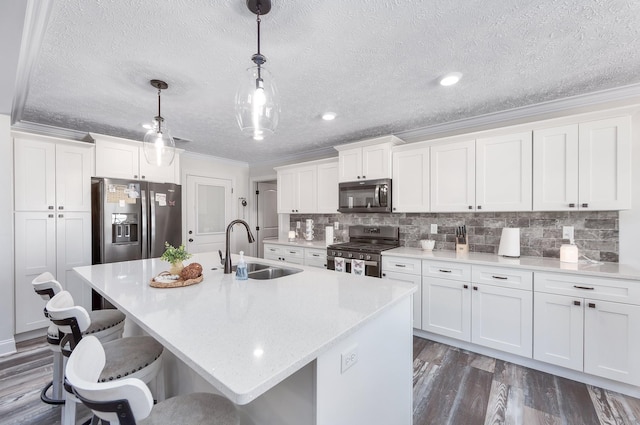 kitchen featuring backsplash, crown molding, a breakfast bar, appliances with stainless steel finishes, and a sink