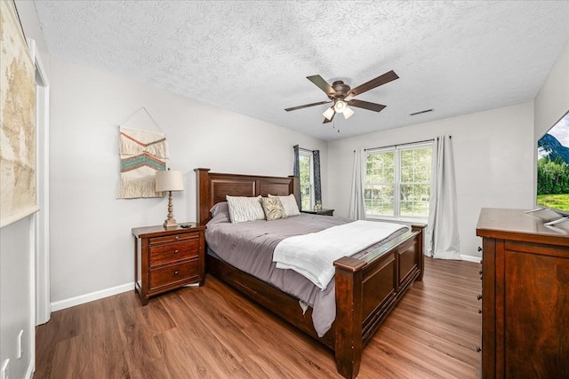 bedroom featuring visible vents, baseboards, and wood finished floors
