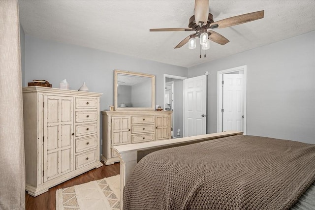 bedroom featuring ceiling fan, a textured ceiling, and dark wood-style floors