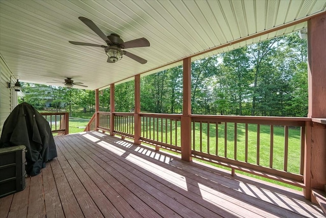 wooden deck with a yard and a ceiling fan