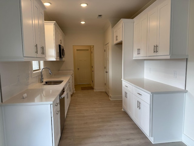 7132 Silverwood Trl, Hermitage, TN 37076 - kitchen with light countertops, light wood-style flooring, stainless steel appliances, white cabinetry, and a sink