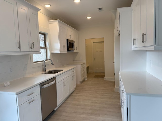 7132 Silverwood Trl, Hermitage, TN 37076 - kitchen featuring visible vents, a sink, light wood-style floors, appliances with stainless steel finishes, and white cabinetry