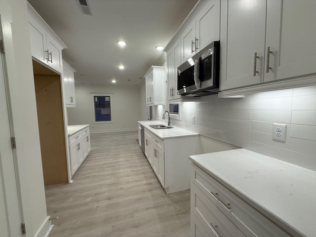 7132 Silverwood Trl, Hermitage, TN 37076 - kitchen with a sink, light countertops, light wood-style floors, appliances with stainless steel finishes, and tasteful backsplash