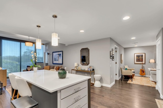kitchen featuring dark wood-type flooring, recessed lighting, light countertops, and baseboards