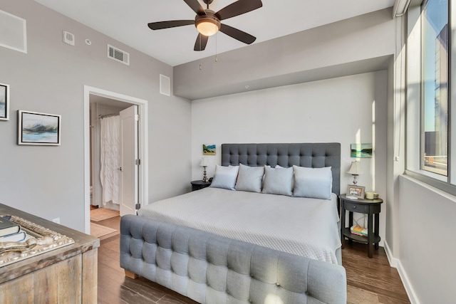 bedroom with visible vents, baseboards, dark wood finished floors, and a ceiling fan