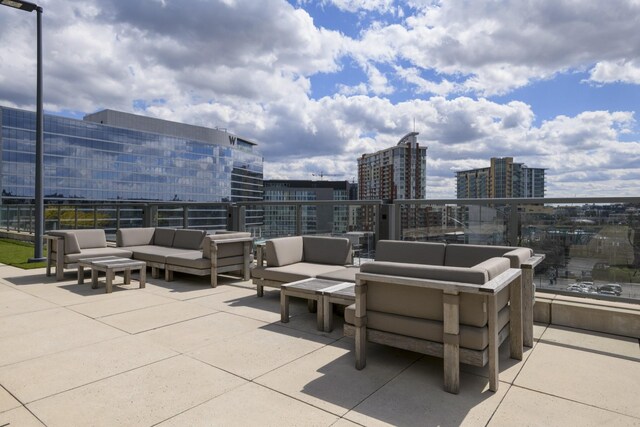 view of patio / terrace with an outdoor living space, a balcony, and a city view