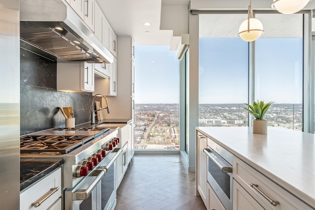 1616 W End Ave Unit 2602, Nashville, TN 37203 - kitchen with under cabinet range hood, stainless steel appliances, plenty of natural light, and decorative backsplash