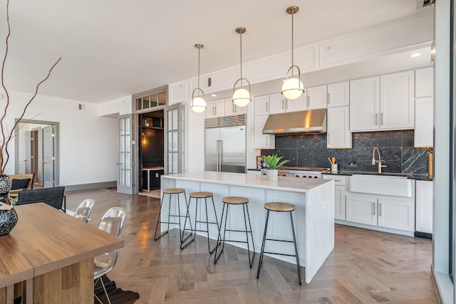 1616 W End Ave Unit 2602, Nashville, TN 37203 - kitchen with a breakfast bar, a sink, stainless steel appliances, under cabinet range hood, and backsplash