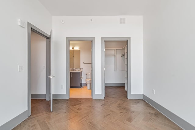 1616 W End Ave Unit 2602, Nashville, TN 37203 - unfurnished bedroom featuring a spacious closet, visible vents, connected bathroom, baseboards, and a closet