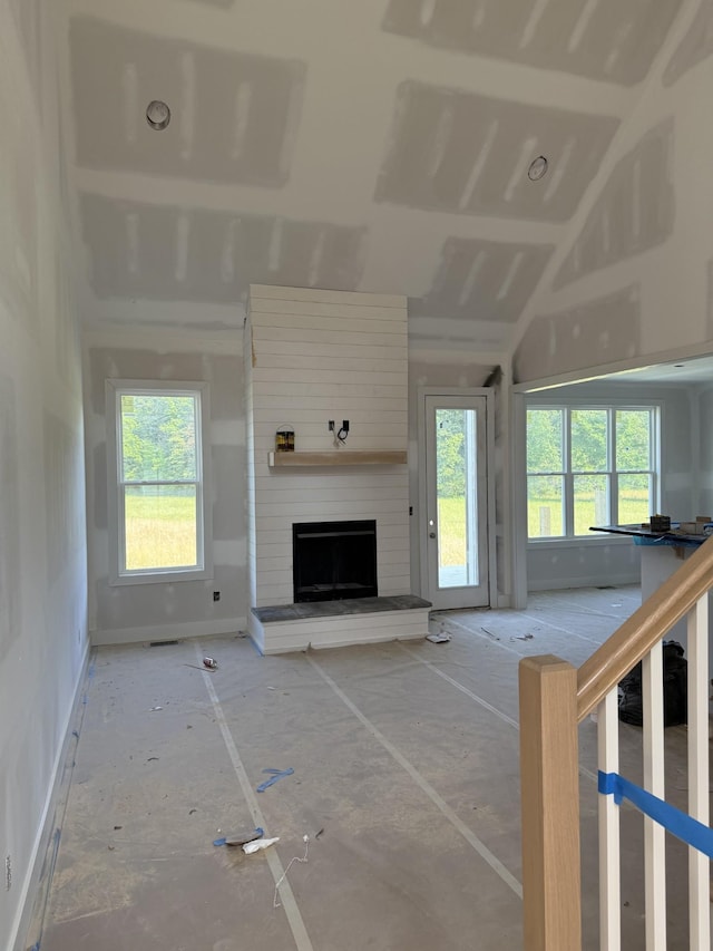1513 Garners Creek Rd, Dickson, TN 37055 - unfurnished living room with baseboards, a large fireplace, and lofted ceiling