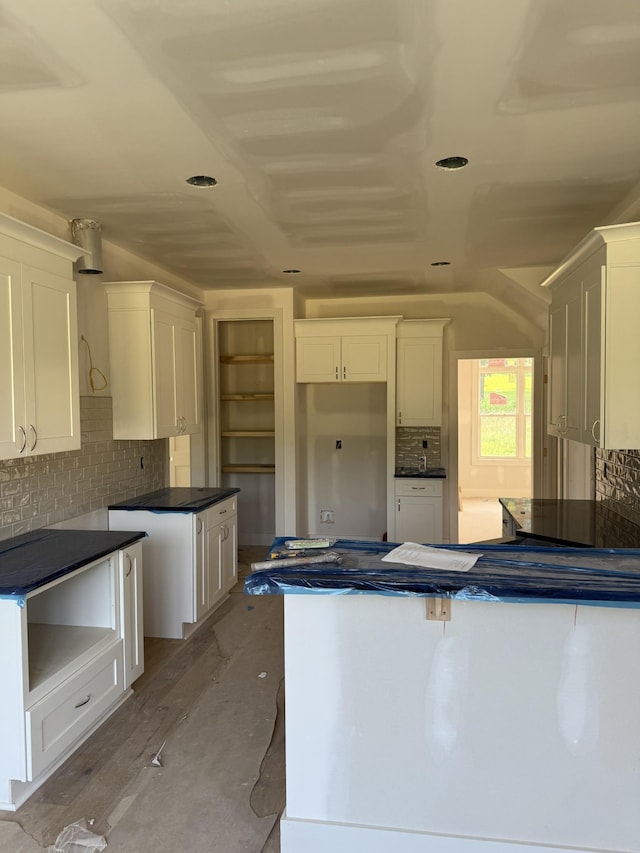1513 Garners Creek Rd, Dickson, TN 37055 - kitchen with decorative backsplash, white cabinets, dark countertops, and a peninsula