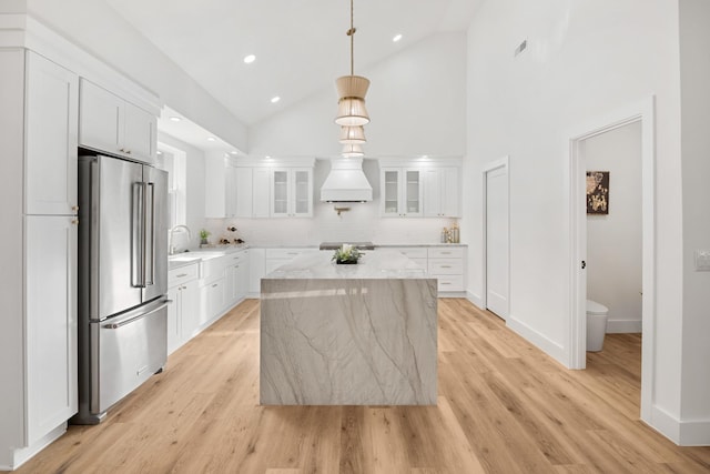 kitchen with light wood-style flooring, appliances with stainless steel finishes, a center island, and a sink