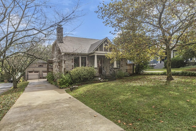 view of front of home with a gate, roof with shingles, concrete driveway, a front yard, and a chimney
