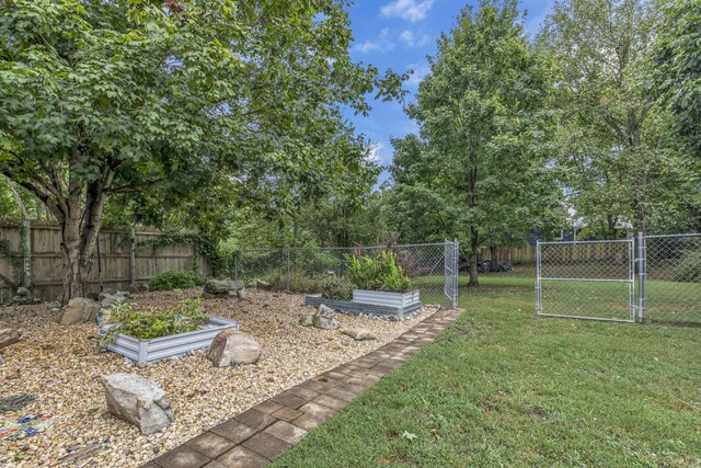 view of yard with a vegetable garden, a gate, and fence private yard