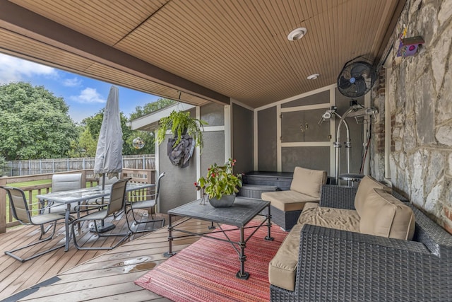 wooden terrace with outdoor dining space and fence