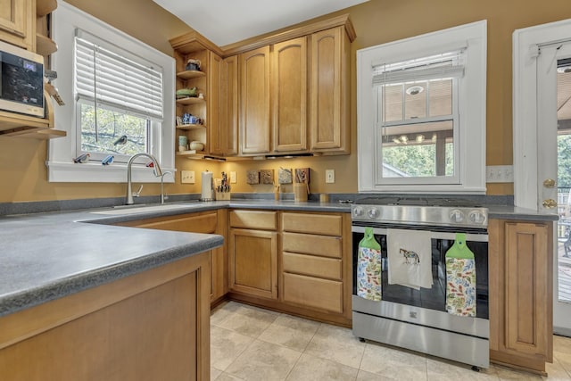 kitchen with light tile patterned floors, open shelves, a sink, stainless steel appliances, and dark countertops