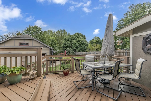 wooden deck with outdoor dining area and fence
