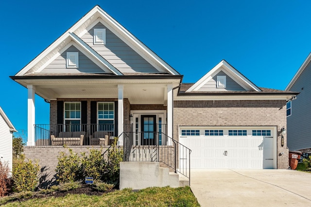view of front facade featuring a garage, brick siding, a porch, and driveway