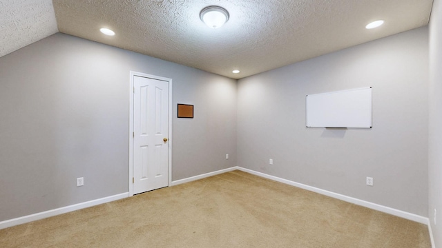 unfurnished room featuring a textured ceiling, recessed lighting, baseboards, and light carpet