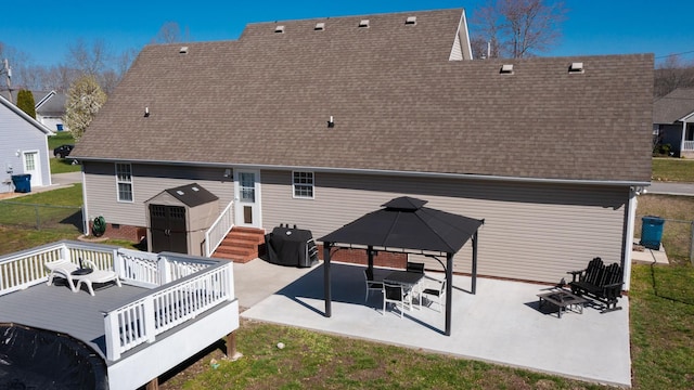 rear view of property featuring entry steps, roof with shingles, a gazebo, a deck, and a patio area