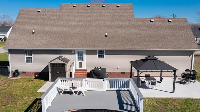 rear view of house featuring a deck, entry steps, a gazebo, a yard, and roof with shingles