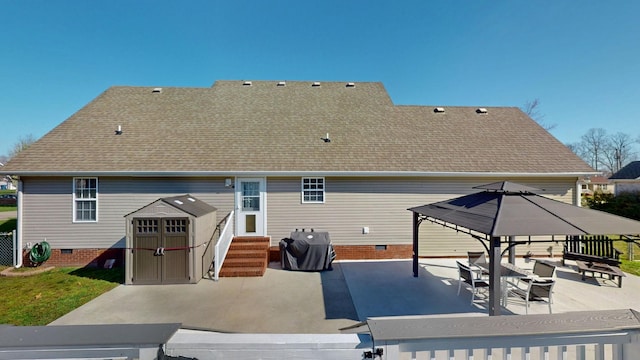 rear view of house with entry steps, a gazebo, a shingled roof, crawl space, and a patio area
