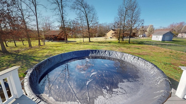 view of pool featuring a yard and fence
